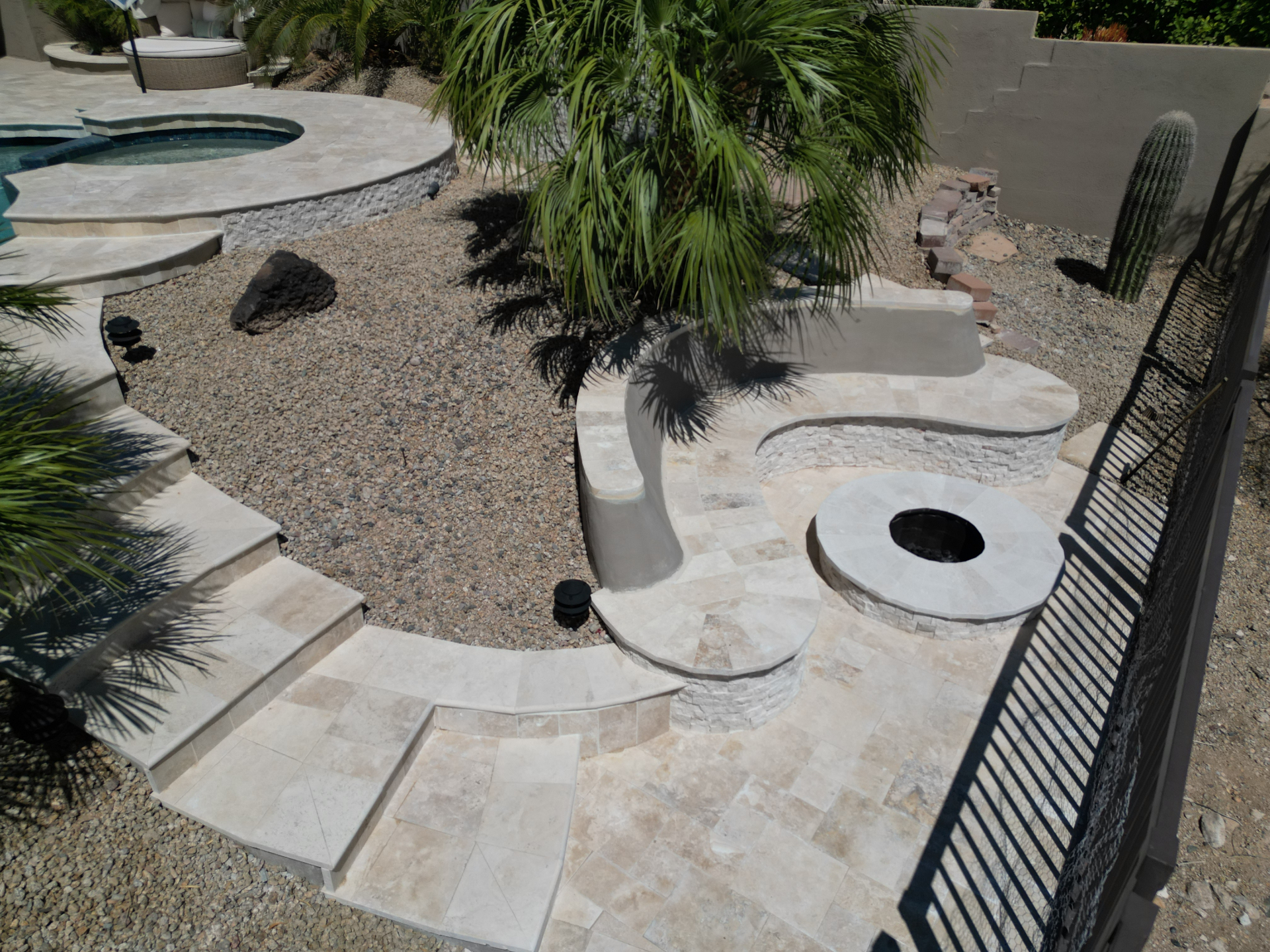 Travertine steps, stacked-stone fire pit and desert landscaping