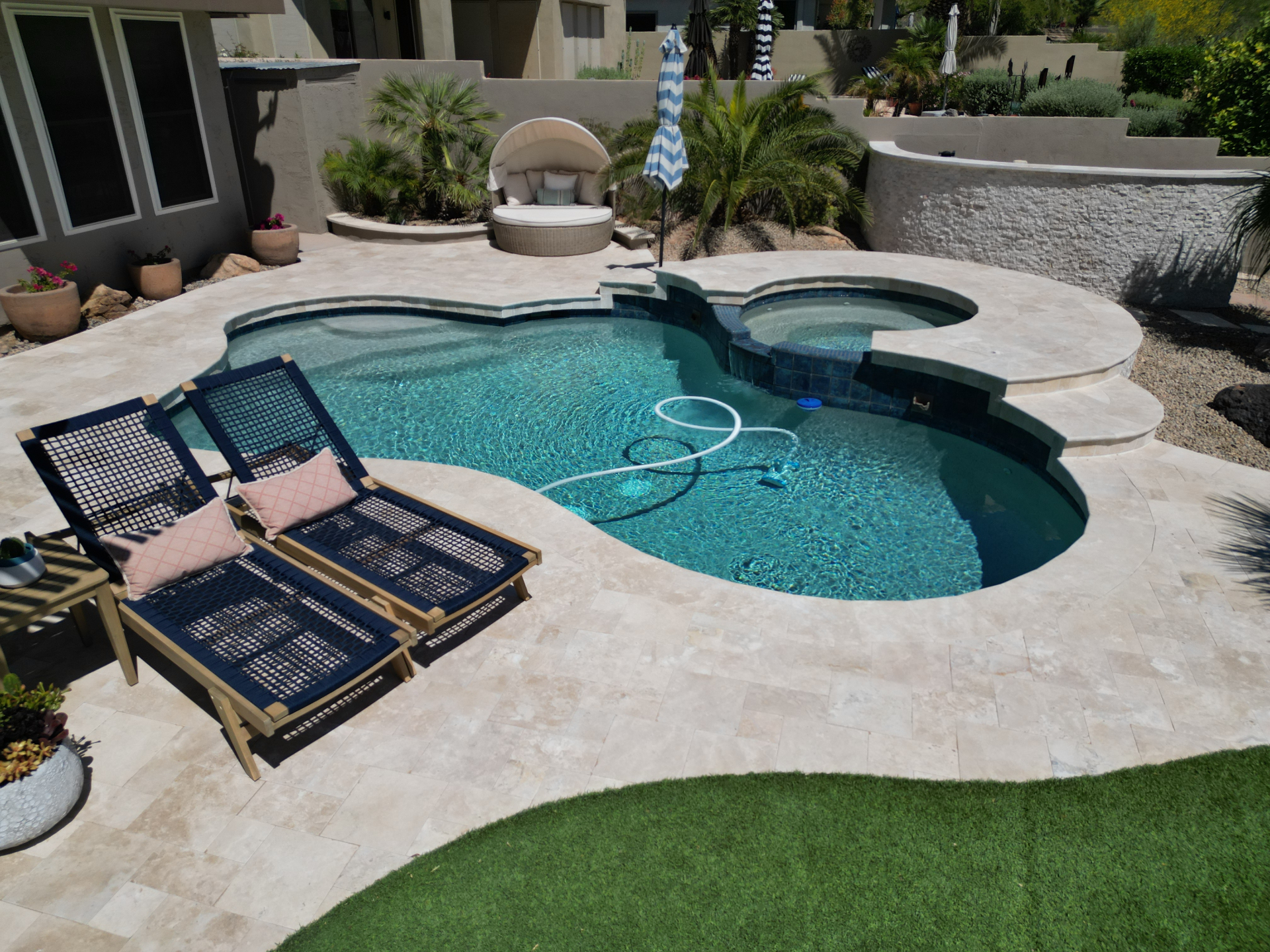Luxury Arizona pool deck with travertine coping and spa surround